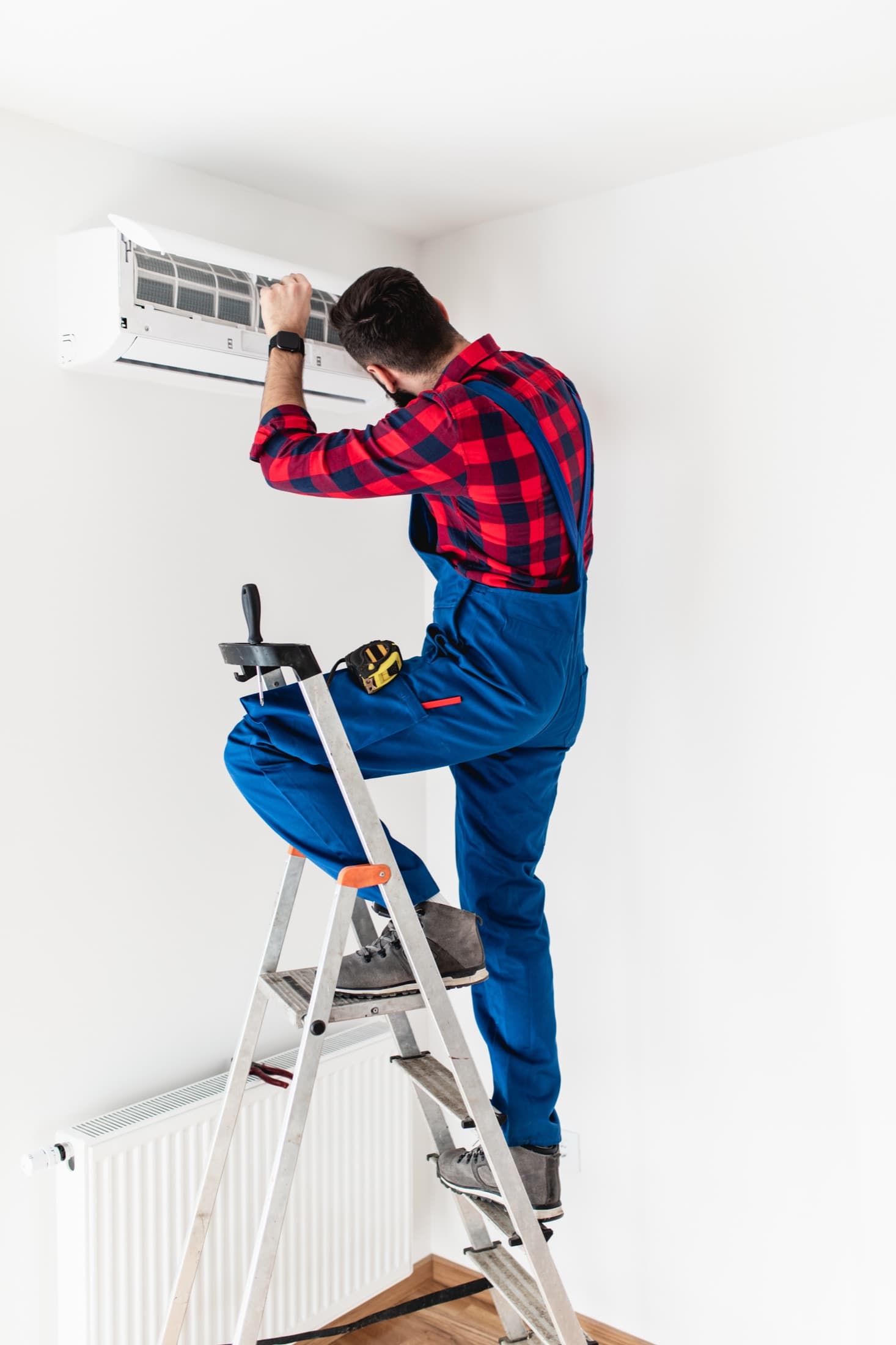 HVAC technician repairing an outdoor air conditioning unit