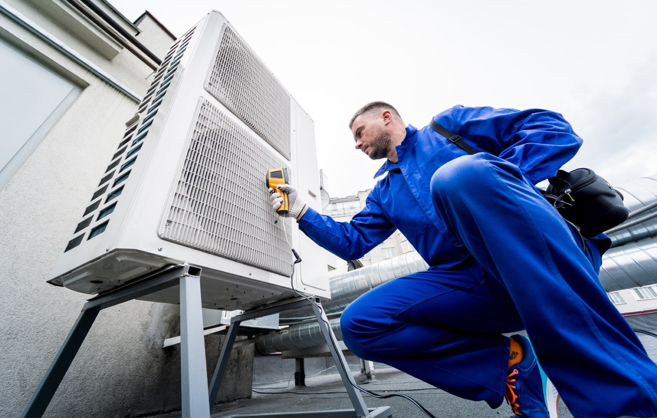 HVAC technician using a thermal imaging thermometer to check a condensing unit