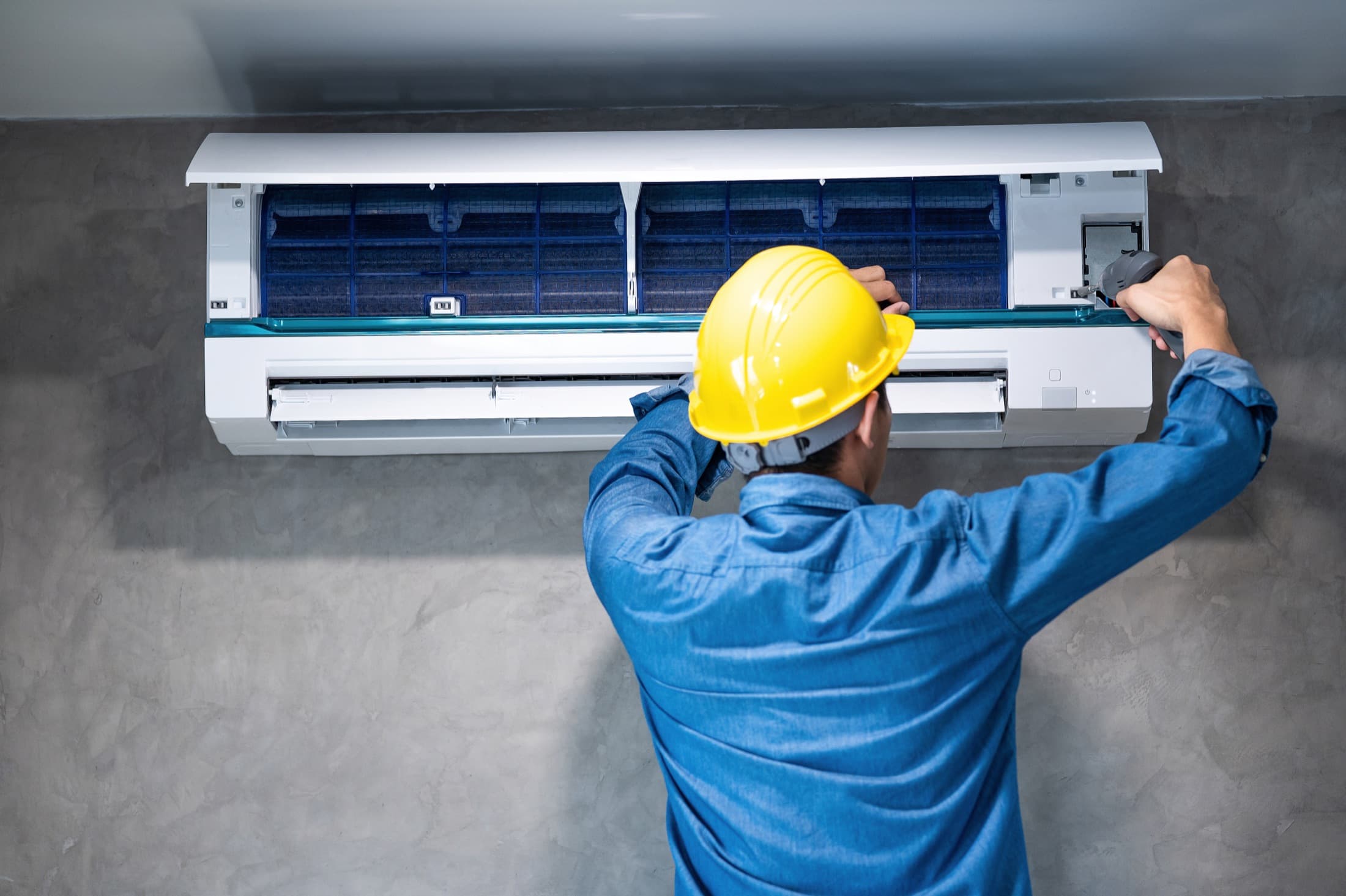 HVAC technician cleaning and repairing an air conditioning unit